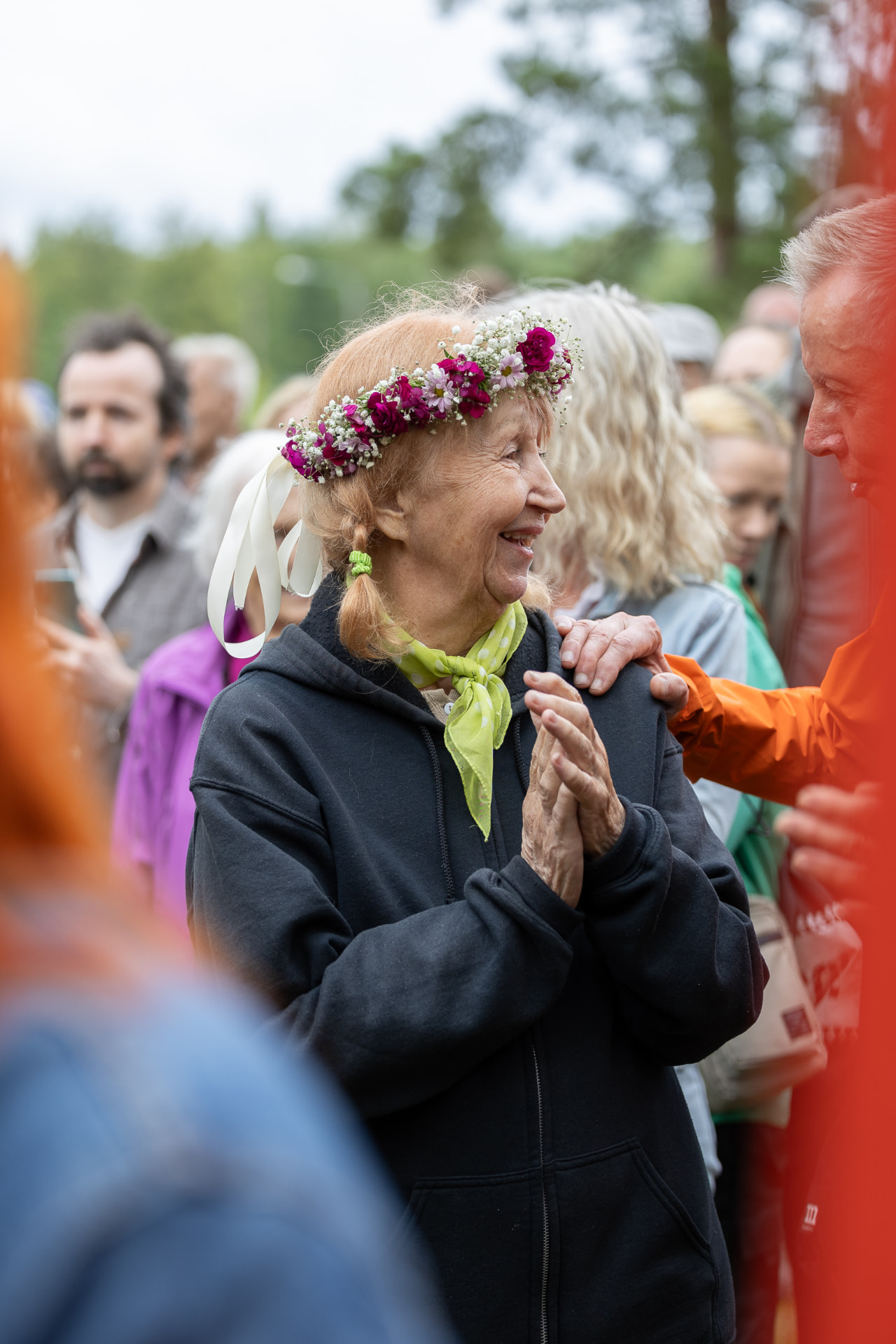 Marjatta kukkaseppeleessä yleisön keskellä hymyilemässä