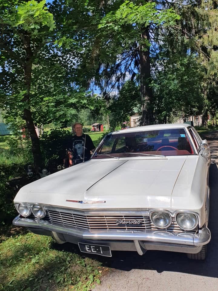 Valkoinen Chevrolet Impala isännän kanssa Elvis-tuvalla